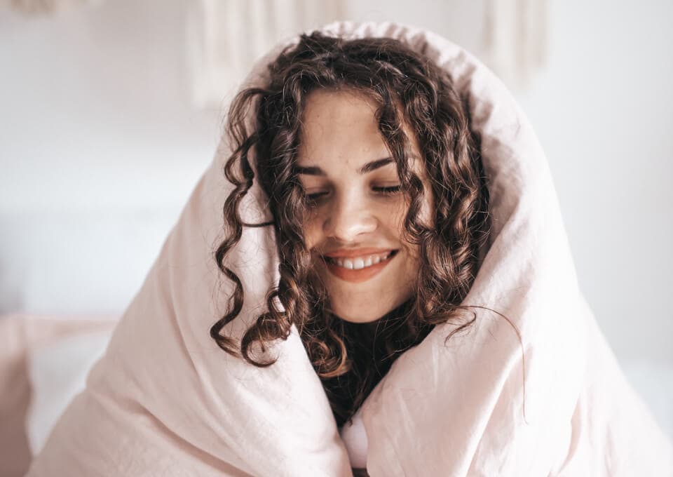 image of a woman snuggled ina a blanket