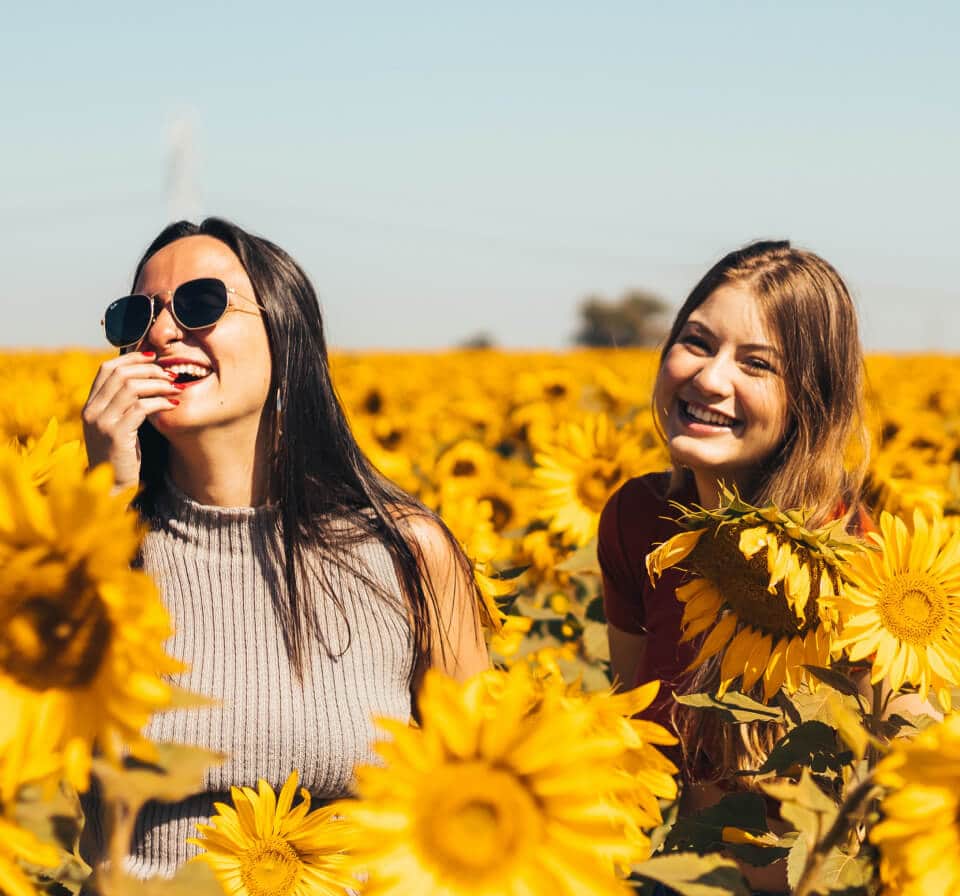 image of two happy women in a sunflower field